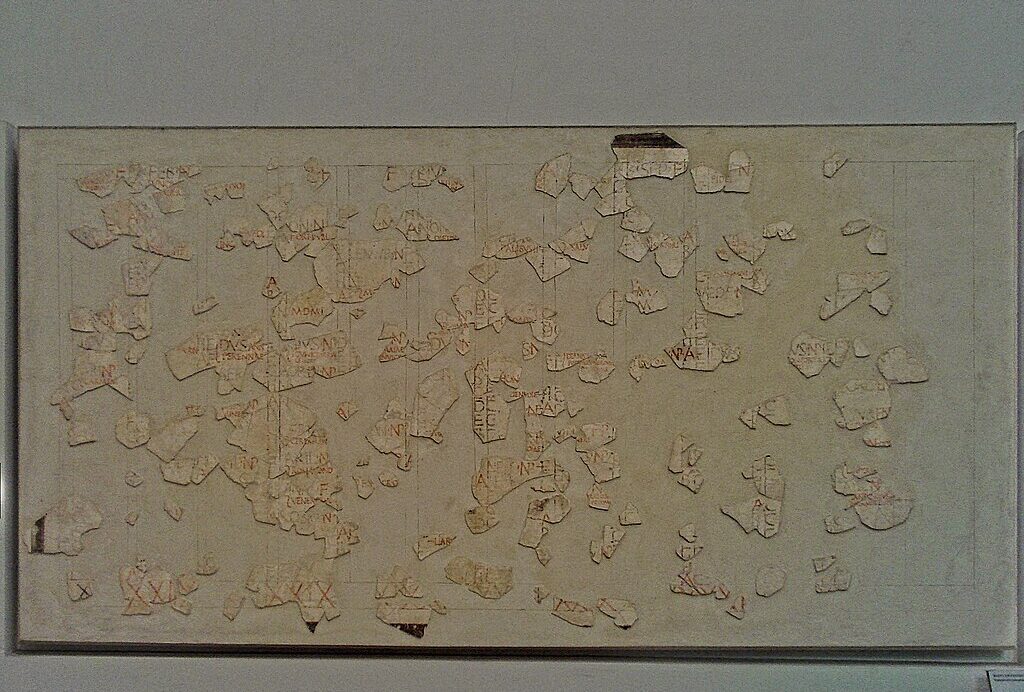 Fragment of the Fasti Antiates, an ancient Roman calendar painted on plaster, showing month names, festival markings, and preserved red and black inscriptions.